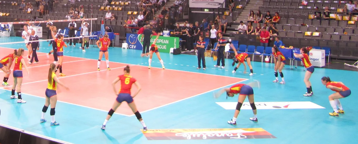 Jugadoras de la selección española de voleibol con camiseta roja calentando antes de un partido en la Porsche Arena de Stuttgart