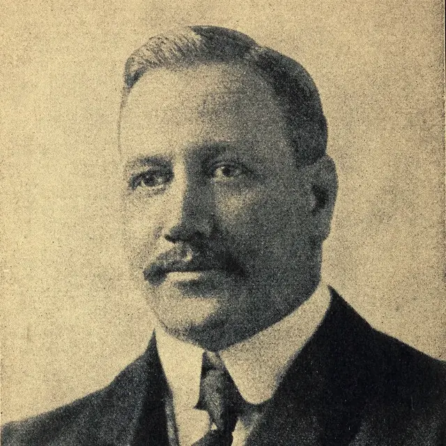 Retrato en blanco y negro de William G. Morgan, inventor del voleibol, con traje y bigote