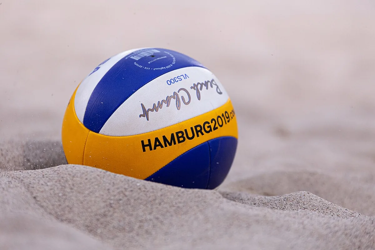 Mikasa VLS300 Beach Champ con el logotipo del Mundial de vóley playa Hamburgo 2019, medio hundido en la arena