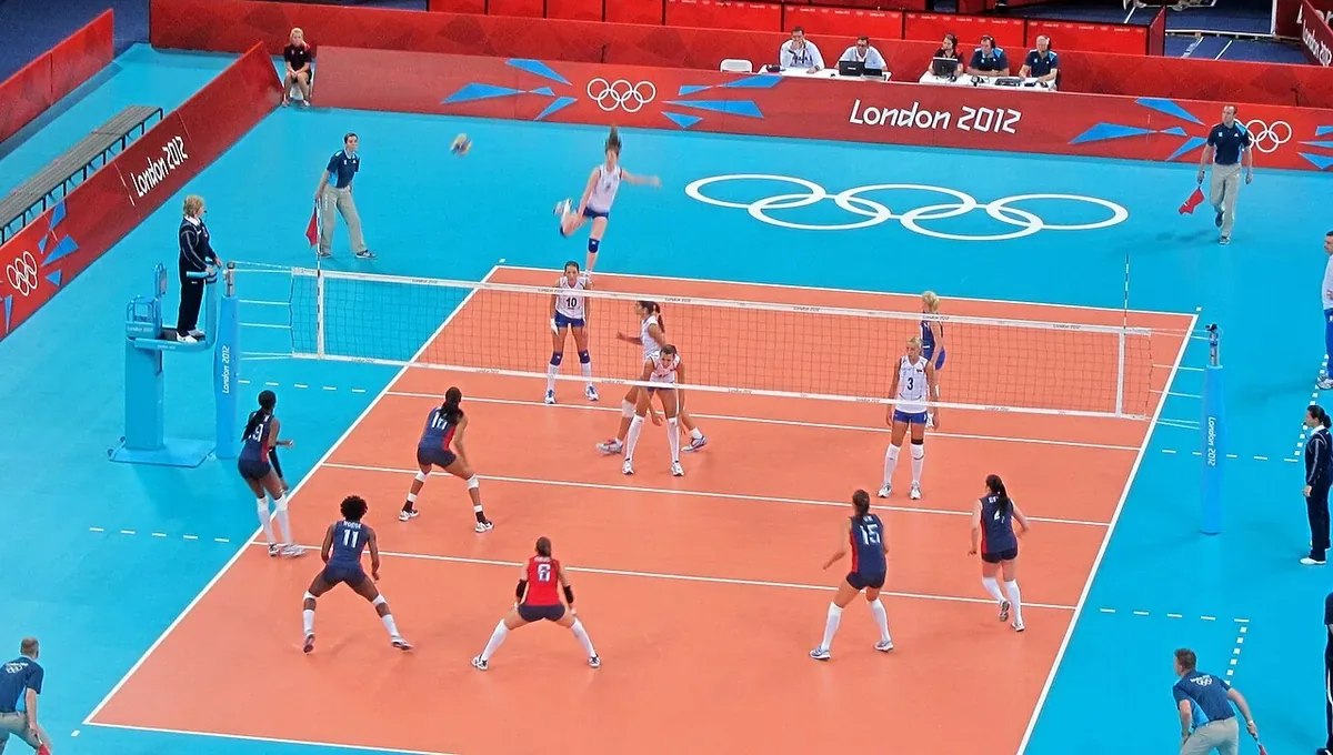 Partido de voleibol femenino de los Juegos de Londres 2012 entre Estados Unidos y Serbia visto desde la grada, con la líbero vestida de rojo en la zaga