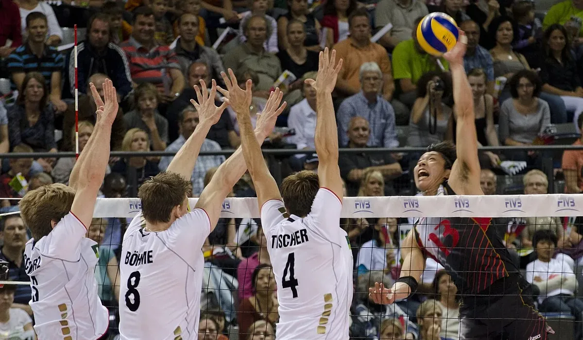 Triple bloqueo de la selección alemana ante el remate de un jugador japonés en la Liga Mundial de voleibol