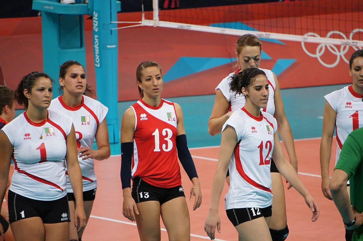 Jugadoras de la selección de Argelia en los Juegos de Londres 2012 con camiseta ceñida, pantalón corto ajustado numerado y la líbero vestida de rojo