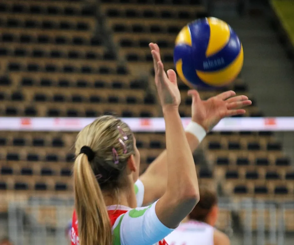 Jugadora de voleibol lanzando el balón por encima de la cabeza antes de un saque por arriba